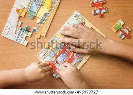 putting a puzzle together Royalty-Free Stock Photo #495999727