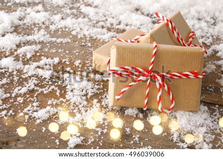Image of handmade gift boxes over snowy wooden table.