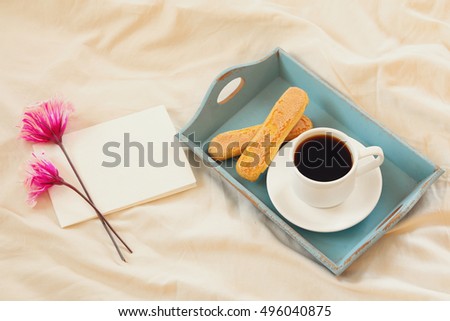 Romantic breakfast in the bed: cookies, hot coffee, flowers and blank note for adding text

