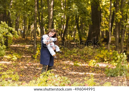 Happy family, motherhood and baby concept. Smiling mother and little daughter playing together in a park.