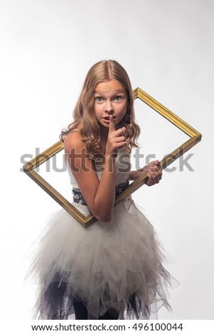 Emotional blonde girl in a white dress in a frame on a white background