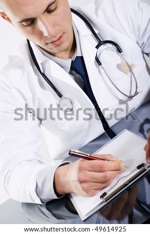 Stock image of doctor wearing lab coat writing on pad