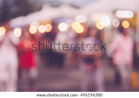 Blur people shopping in local street night market with colorful bokeh and sun light abstract background. Copy space of travel and business concept. Vintage tone filter color style.