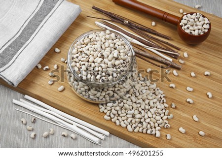 top view navy bean, white kidney bean or white bean in glass cup on wood table, benefits for diet, weight control and diabetes because phaseolamin, with space for your text or crop