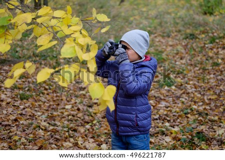 Boy of primary school age pictures of the autumn foliage in the Park