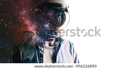 Casually dressed sad looking man in a large helmet with bright stars and galaxies projected on the shield and behind his back with white background in front of him. Double exposure Royalty-Free Stock Photo #496226890