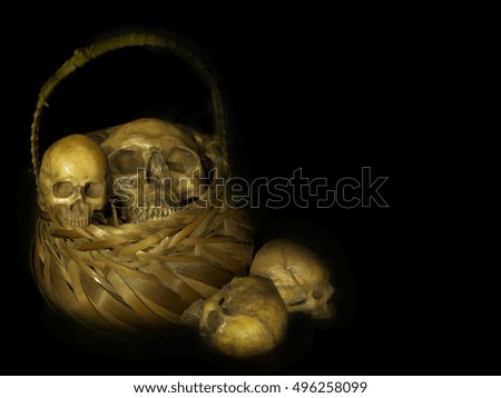 skulls and wicker basket on black background