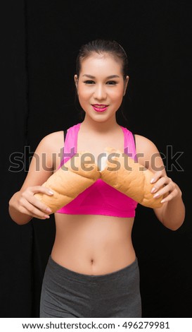 Picture of the smiling girl with a great bread in studio on black background
