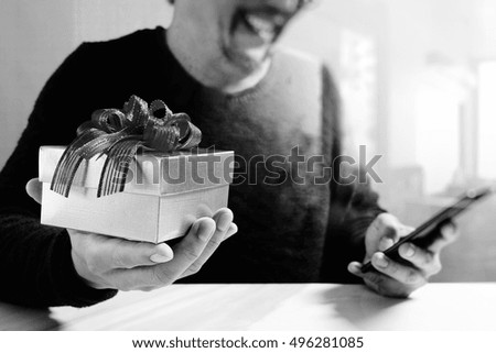 Creative choosing gift with laptop computer and smart phone on mable desk,filter film effect,black and white