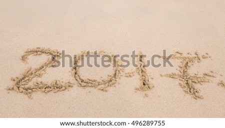 New Year 2017 is coming concept - inscription 2017 on a beach sand Royalty-Free Stock Photo #496289755