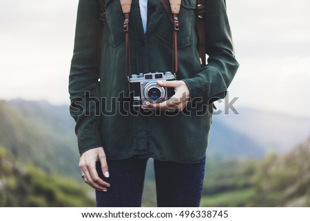 Hipster girl with backpack enjoying sunset on peak of foggy mountain, tourist traveler photographer taking pictures of amazing landscape on vintage photo camera on background valley view mockup sun