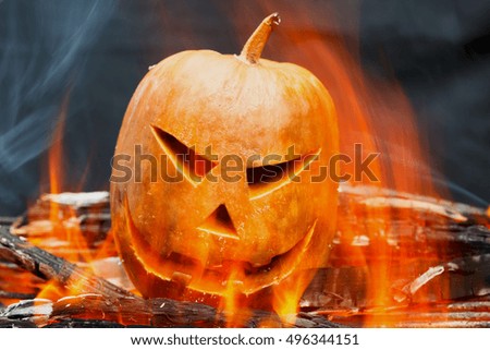 Burning Halloween pumpkin over a black background
