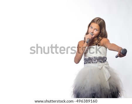 Emotional blonde girl in a white dress singing into a microphone on a white background