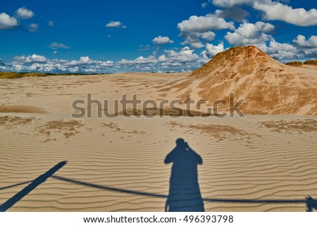 Silhouette of a Photographer taking picture of Leba Dunes on Polish Baltics shore