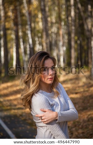 portrait of a beautiful girl in the autumn forest with yellow birch leaves.
