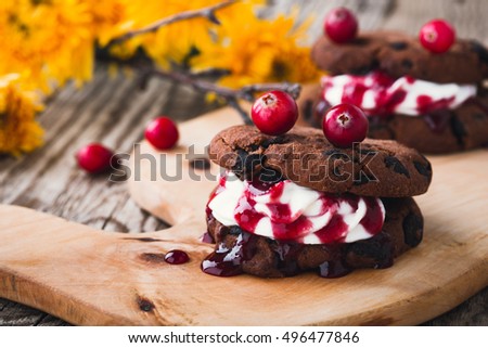 Vampire chocolate chip cookie sandwiches on background autumn yellow chrysanthemum, homemade festive Halloween dessert