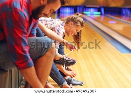 Picture showing friends putting on bowling shoes