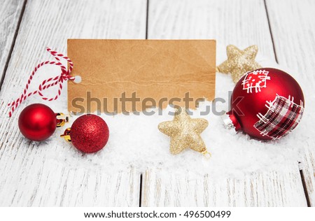 christmas background - blank paper card and baubles in the snow