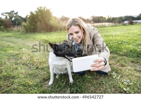Beautiful woman with dog in taking selfie, nature.