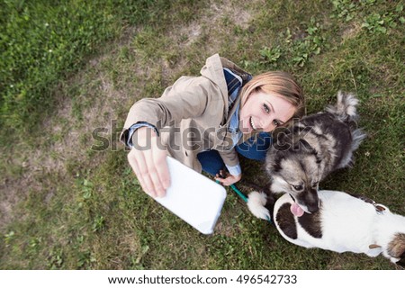 Beautiful woman with dog in taking selfie, nature.