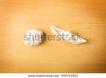 great ideas come from simple steps concept, thinking differently concept, paper boat and paper on wood background