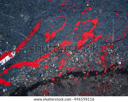 Drops of red paint stain on the asphalt great urban city background image