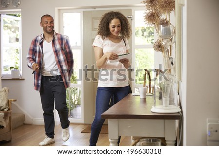Couple In Hallway Returning Home Together Royalty-Free Stock Photo #496630318