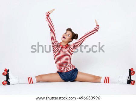 Beautiful woman in the roller-skates and with red headphones in studio