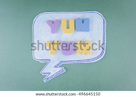 Speech bubbles handmade and Emotional Yum yum on a green background.