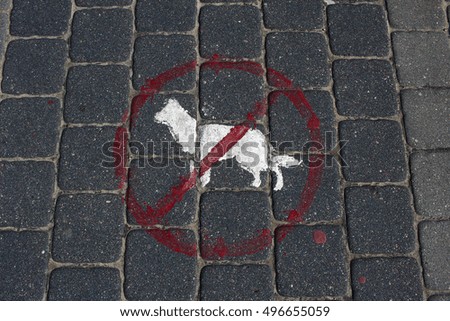 No dogs red sign on a pavement and white picture icon of a dog