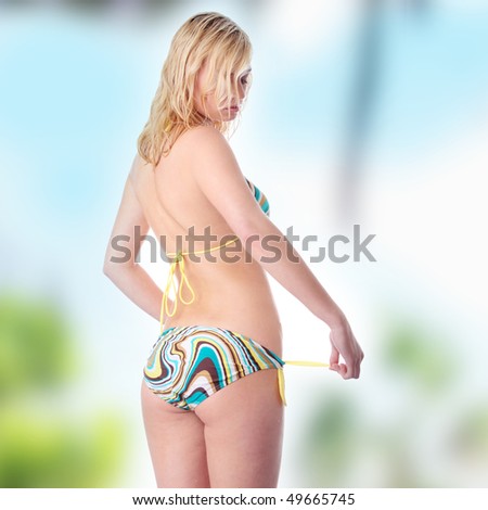 Young beautiful tanned blond warm woman in bikini