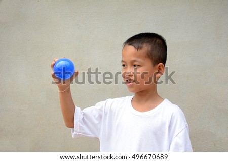 Asian boys play toy ball.Cement gray background