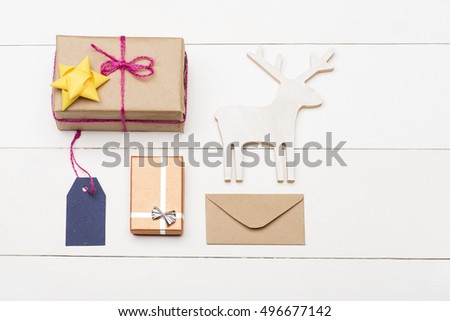 Colorful Christmas or New Year decoration with gift with rose thread, golden yellow bow, Christmas deer, envelope, gift with silver bow, blue tag with rose thread, on vintage white background.