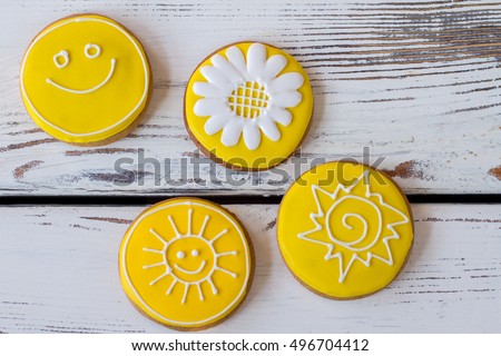 Top view of iced cookies. Round biscuits on wooden background. Flower and smiling sun. Art starts from imagination.