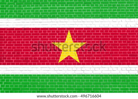 Surinamese national official flag. Patriotic symbol, banner, element, background. Flag of Suriname on brick wall texture background