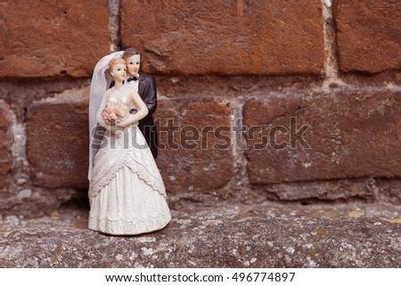 Groom and bride near the brick wall with space for text