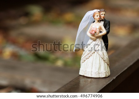 Groom and bride on the railway track. Picture with space for text. Little wedding cake topper