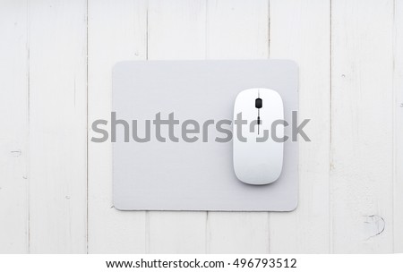 White wireless mouse on a mouse pad, top view Royalty-Free Stock Photo #496793512