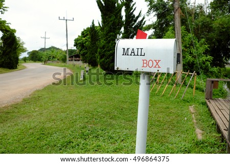 mailbox on the white pole beside the way