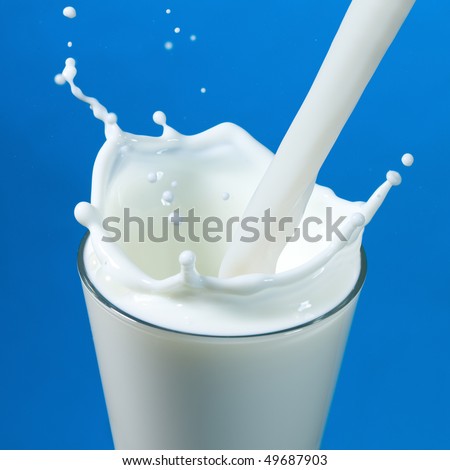 pouring milk in a glass isolated against white background