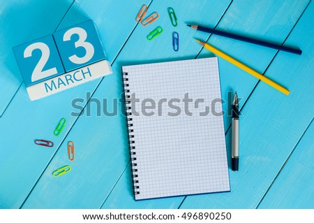 March 23rd. Day 23 of month, calendar on blue wooden table background with notepad. Spring time, empty space for text Royalty-Free Stock Photo #496890250
