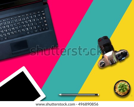 Camera,tablet,notebook, pencil and cactus on colorful background.
