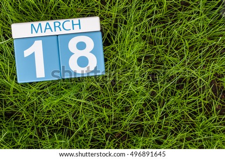 March 18th. Day 18 of month, calendar on football green grass background. Spring time, empty space for text