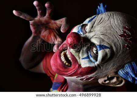 closeup of a scary evil clown against a black background