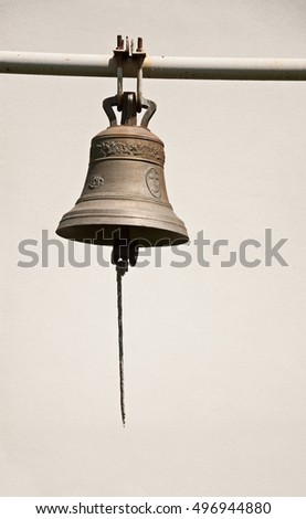 Old bronze bell on background of white wall