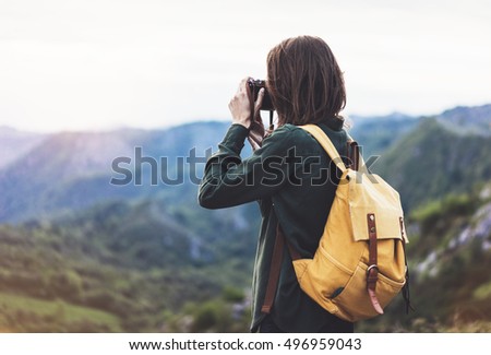 Tourist traveler photographer taking pictures of amazing landscape on vintage photo camera on background valley view mockup sun flare, hipster girl with backpack enjoying sunset on foggy mountain