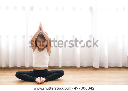 asian little cute girl do a yoga at home with space for add text Royalty-Free Stock Photo #497008042