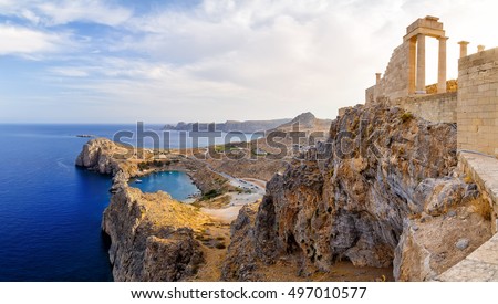 Greece. Rhodes. Acropolis of Lindos. Doric columns of the ancient Temple of Athena Lindia the IV century BC and the bay of St. Paul Royalty-Free Stock Photo #497010577