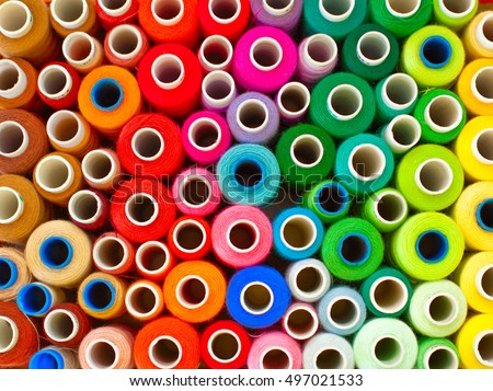 Colored thread for sewing. Threads in spools tape measure, needle bar, needle and scissors on a white background. Royalty-Free Stock Photo #497021533