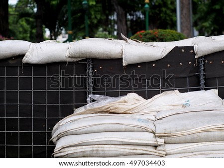 flood water dam barrier wall made of large cube dark color sand bags and small white sandbags installed semi-permanentÂ along CHAO PHRAYA riverside in BANGKOK, THAILAND prepare for urban protection
